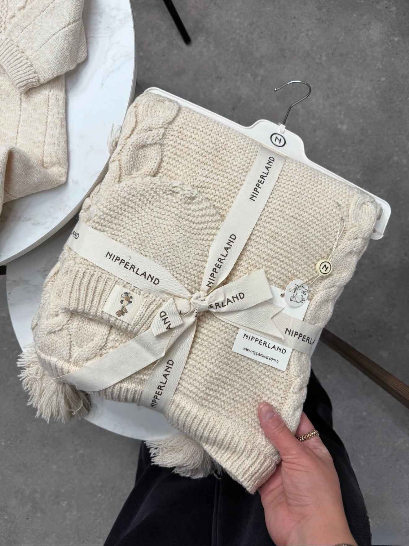 Coperta con pom-pon imbottita e cappellino unisex