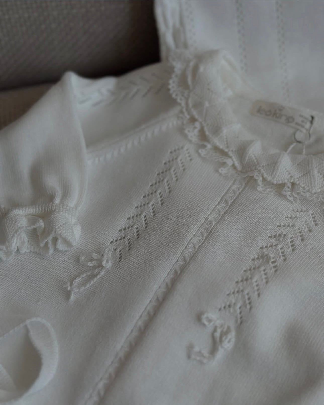 Tutina neonata con dettagli ricamati e cappello coordinato